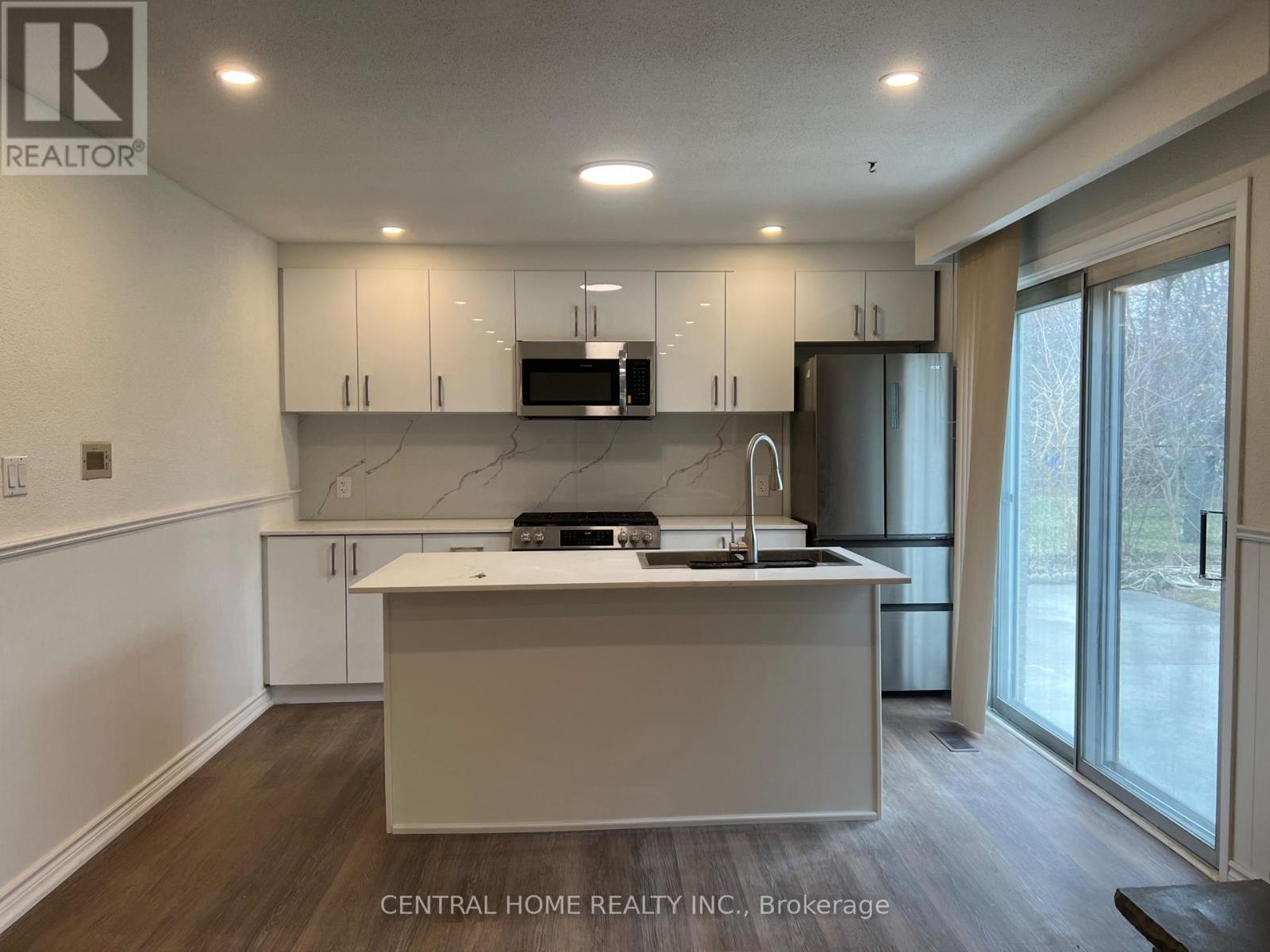 A kitchen with a white countertop and cabinets.