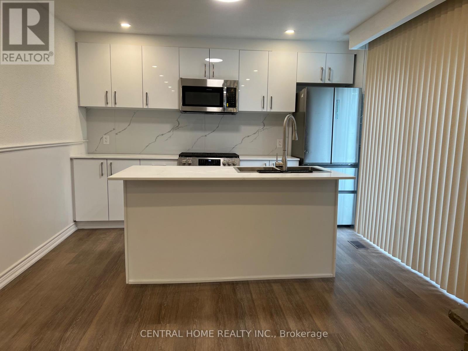 A kitchen with white cabinets and a wooden island.