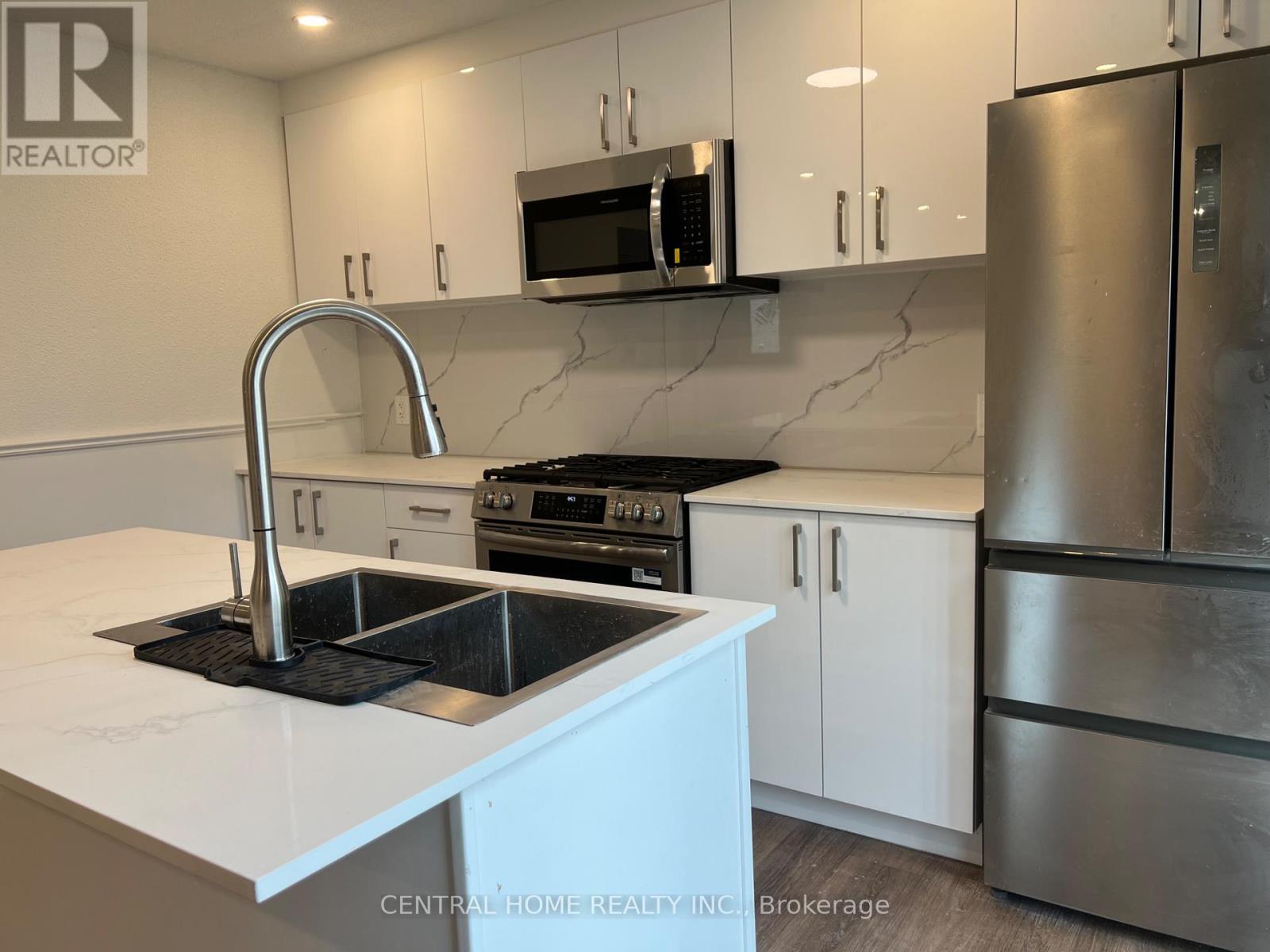 A kitchen with a sink and a refrigerator.