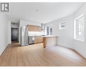 A kitchen with a refrigerator, oven, and cabinets.