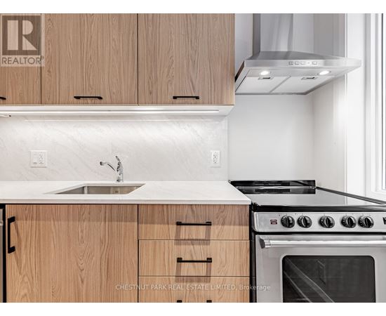 A modern kitchen with wooden cabinets and a stainless steel oven.