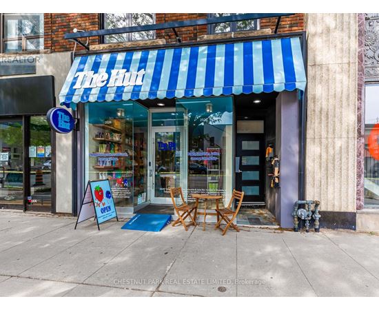 A storefront with a blue and white striped awning.