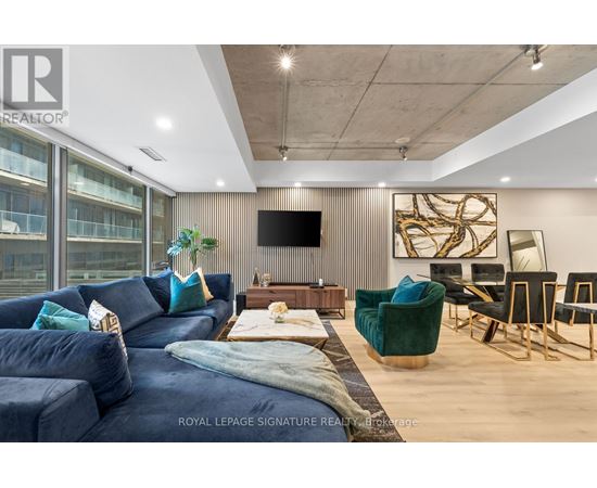 A living room with a blue couch and a television on the wall.