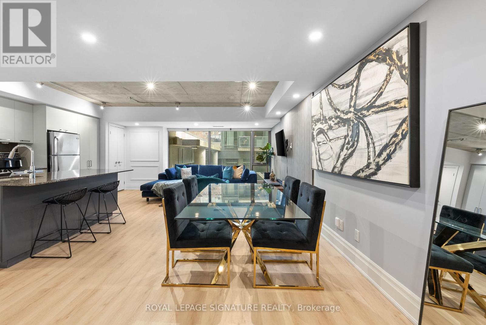 A modern living room with a glass table and black chairs.