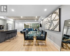 A modern living room with a glass table and black chairs.