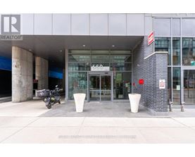 A motorcycle is parked outside a building with a glass door entrance.