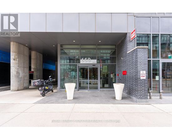 A motorcycle is parked outside a building with a glass door entrance.