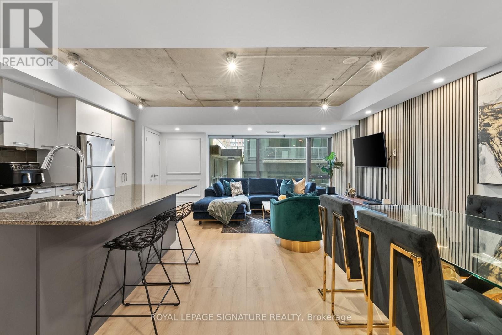 A modern kitchen with a bar area and a living room area.