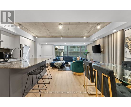 A modern kitchen with a bar area and a living room area.