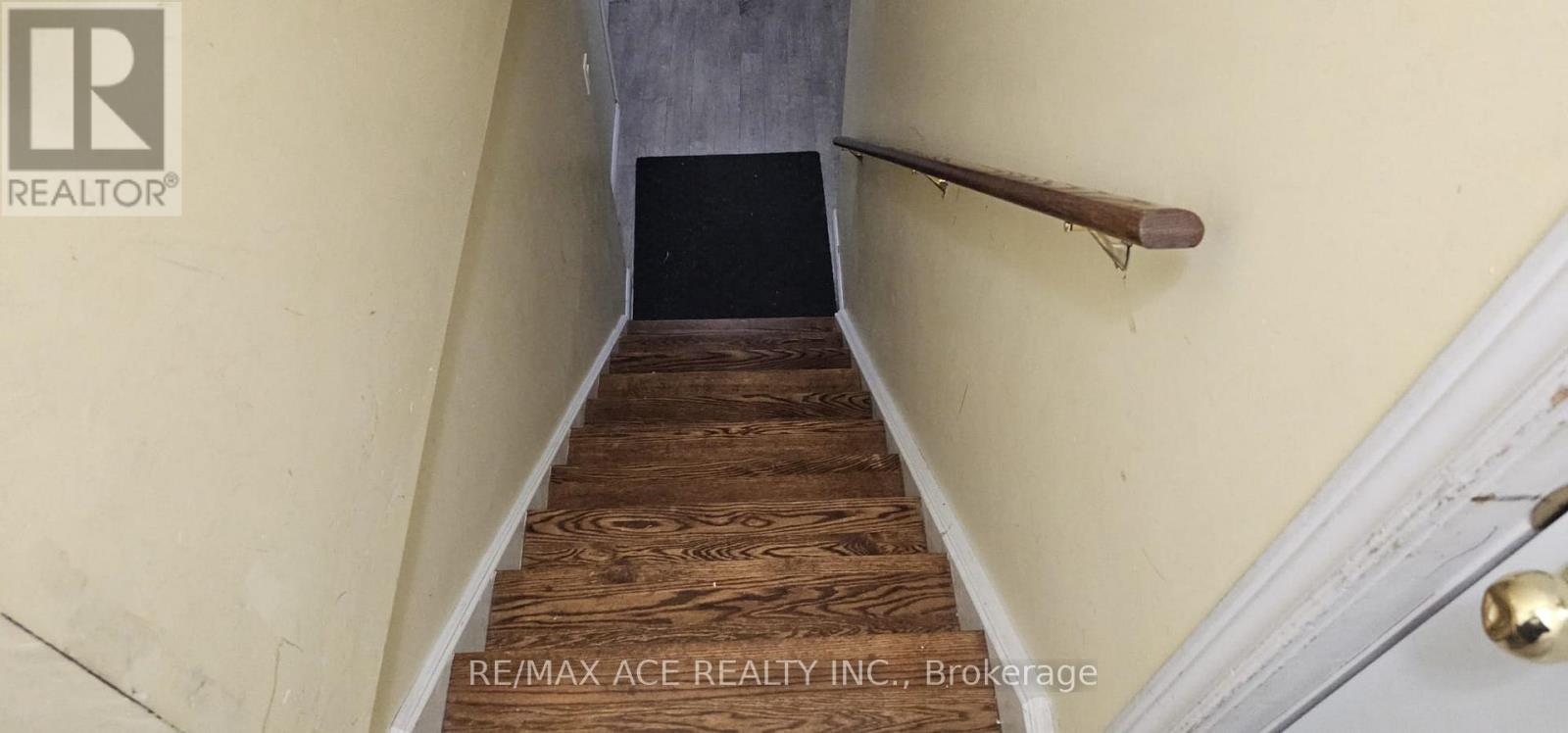 A staircase with wooden steps and a metal handrail.