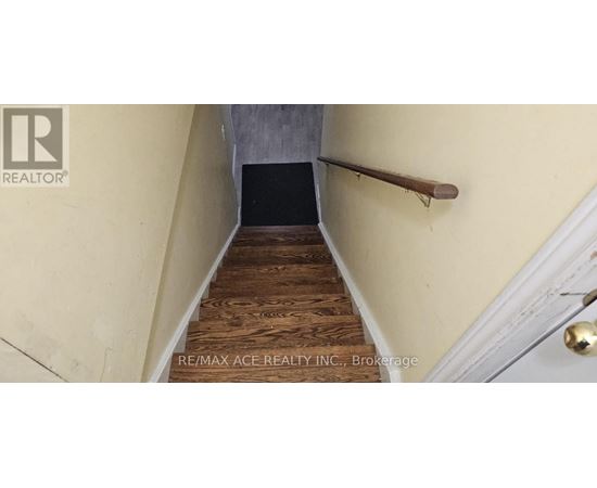 A staircase with wooden steps and a metal handrail.