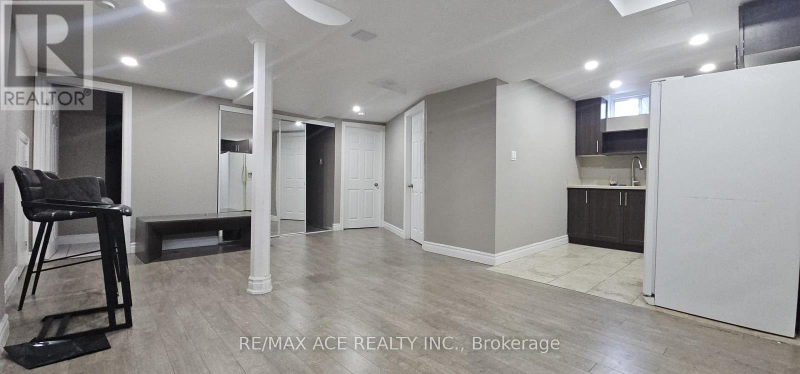 A spacious room with a kitchenette and a dining area.