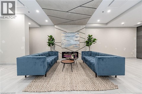 A living room with a blue couch and a rug.