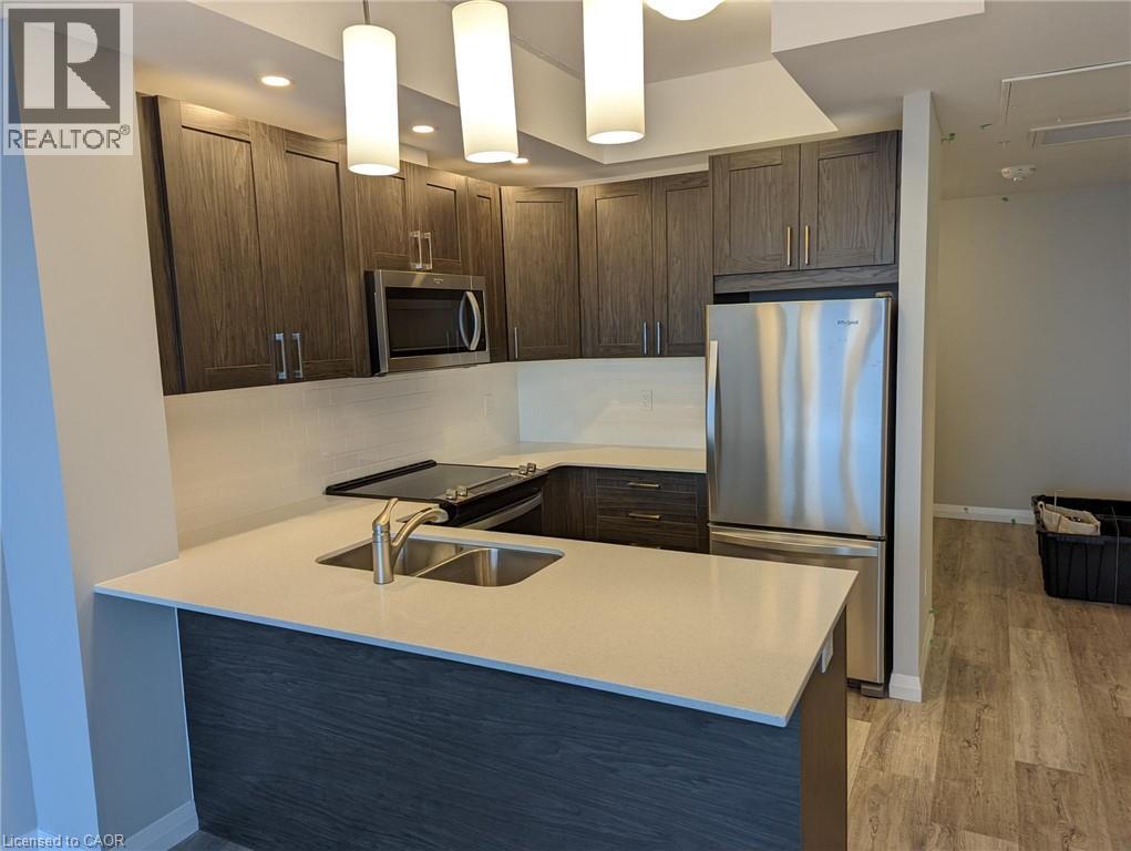 A modern kitchen with a white countertop and stainless steel appliances.