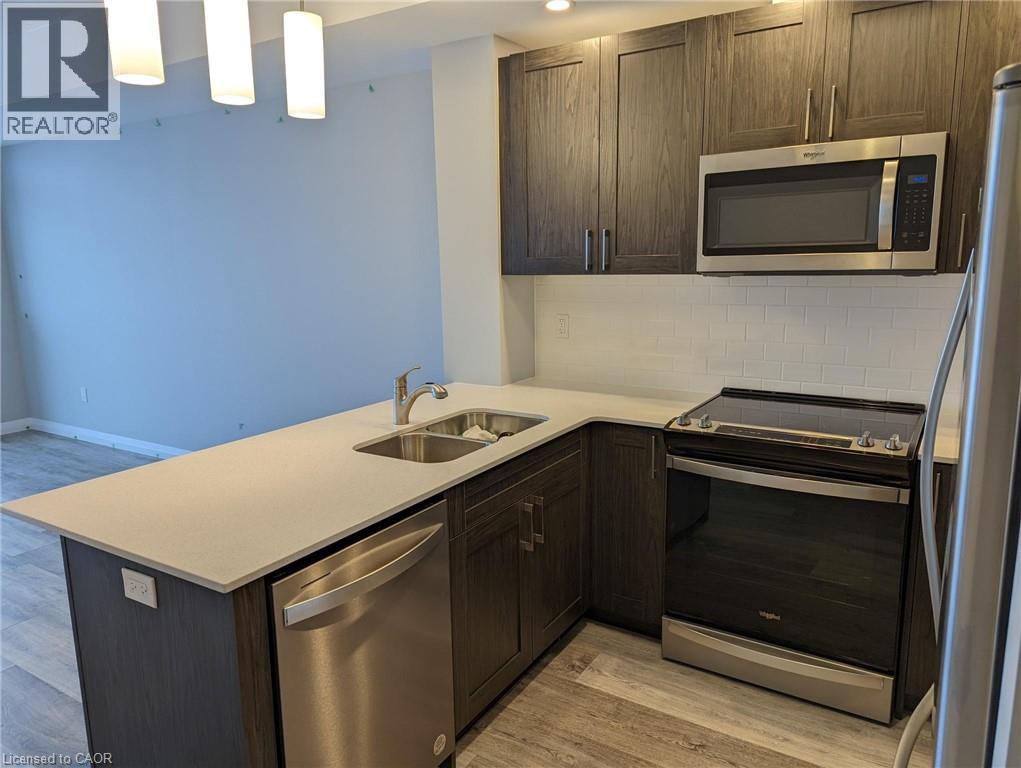 A kitchen with a sink, stove, and refrigerator.