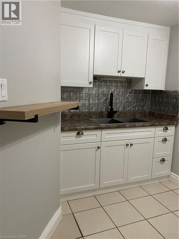 A kitchen with white cabinets and a granite countertop.