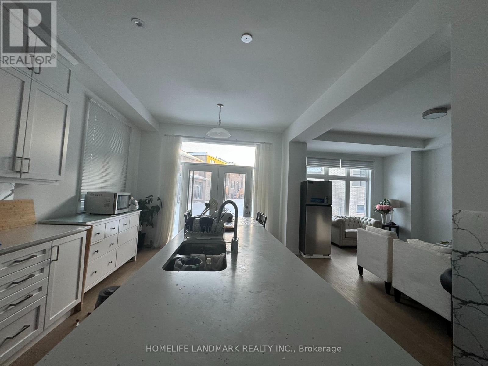 A kitchen with white cabinets and a marble countertop.