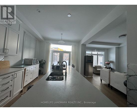 A kitchen with white cabinets and a marble countertop.
