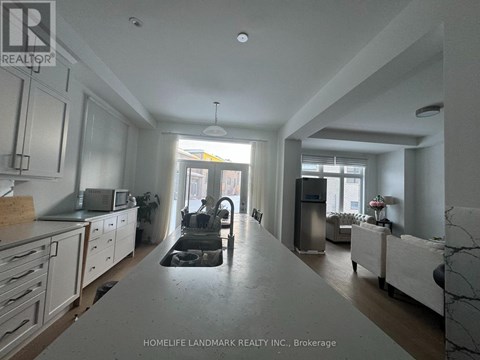 A kitchen with white cabinets and a marble countertop.