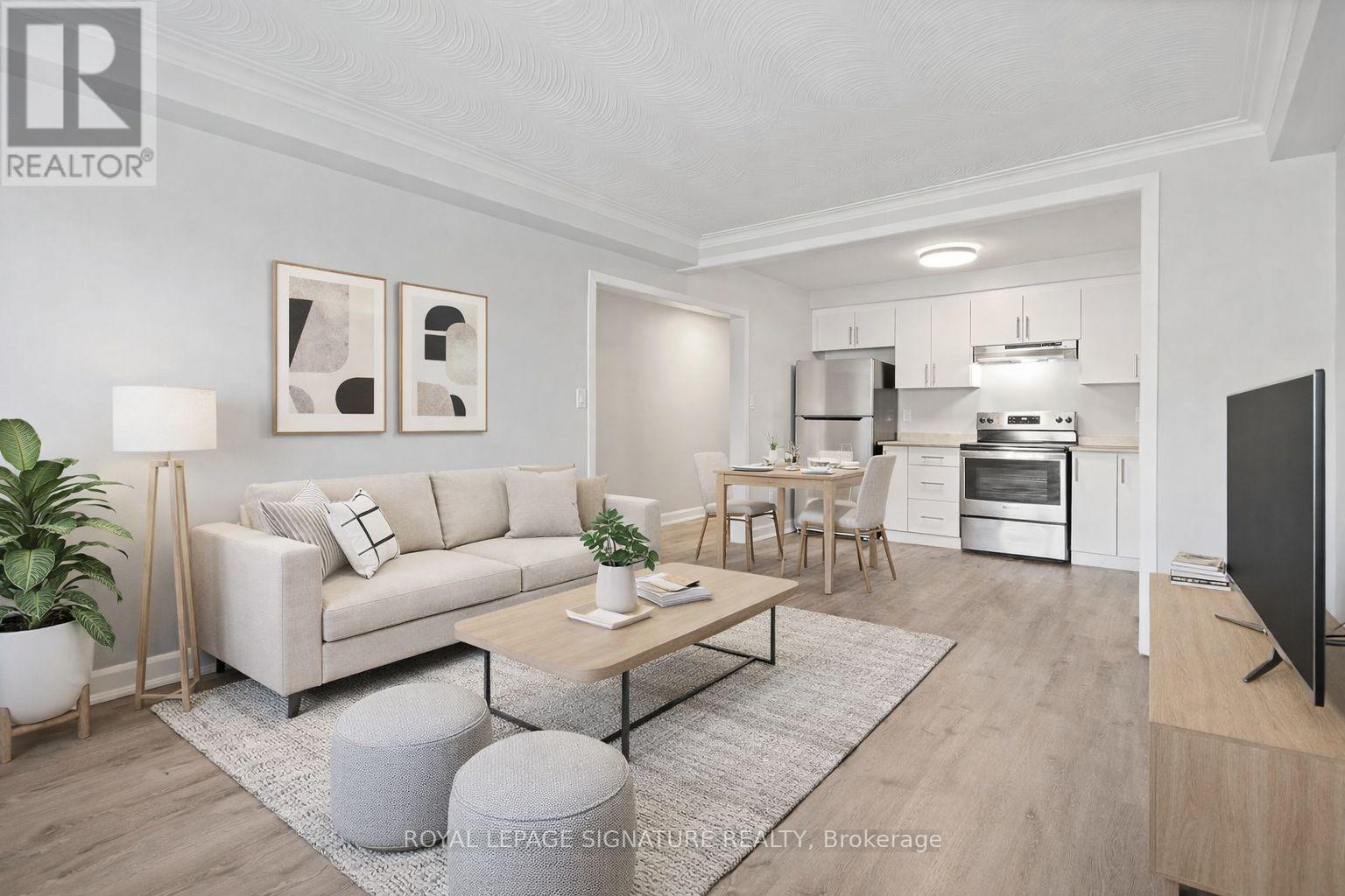 A modern living room with a white sofa, a wooden coffee table, and a flat-screen TV.