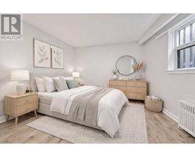 A bedroom with a bed, nightstands, and a window.