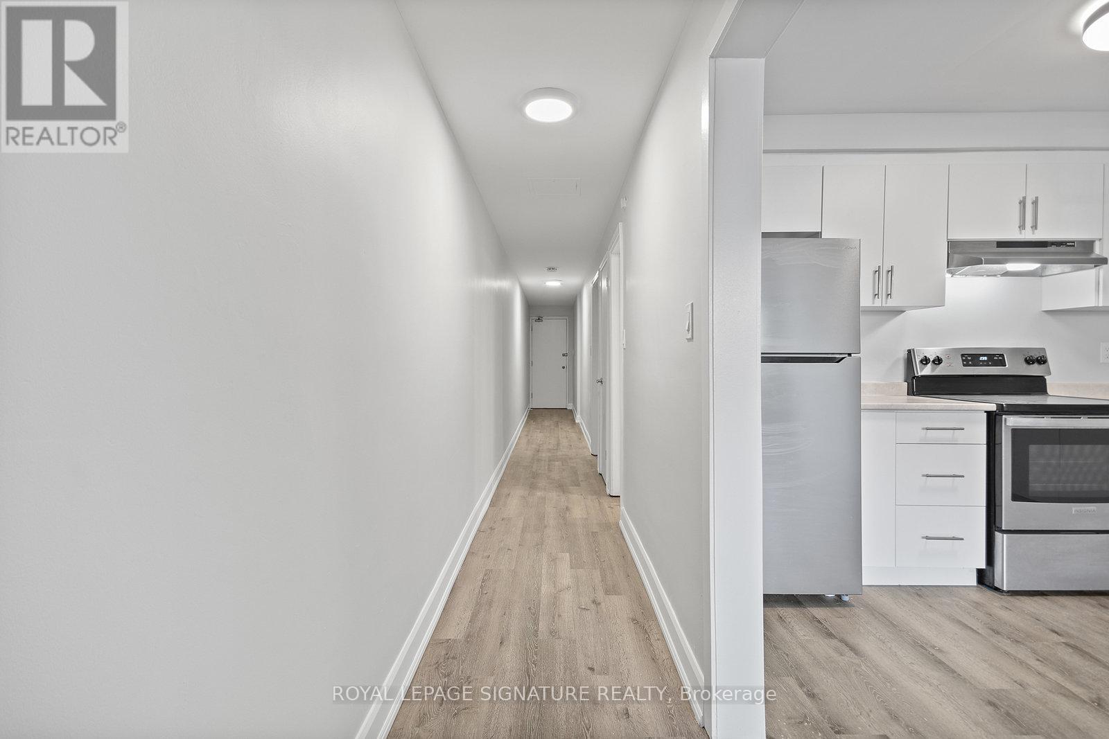 A long hallway with a kitchen on the other side.