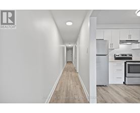 A long hallway with a kitchen on the other side.
