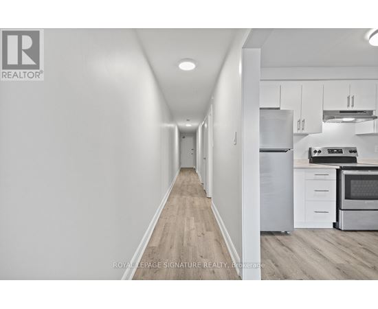 A long hallway with a kitchen on the other side.