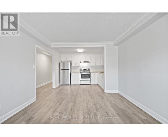 A kitchen with white cabinets and a stainless steel refrigerator.