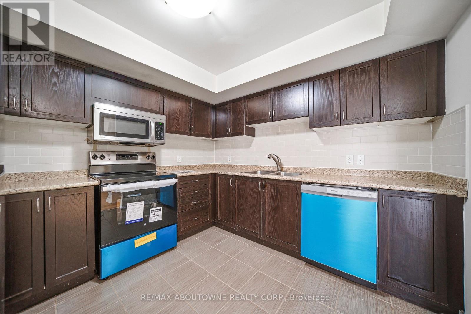 A kitchen with brown cabinets and a blue fridge.