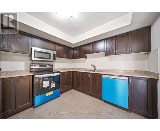 A kitchen with brown cabinets and a blue fridge.