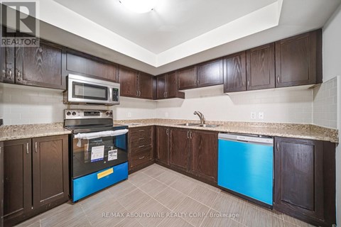 A kitchen with brown cabinets and a blue fridge.