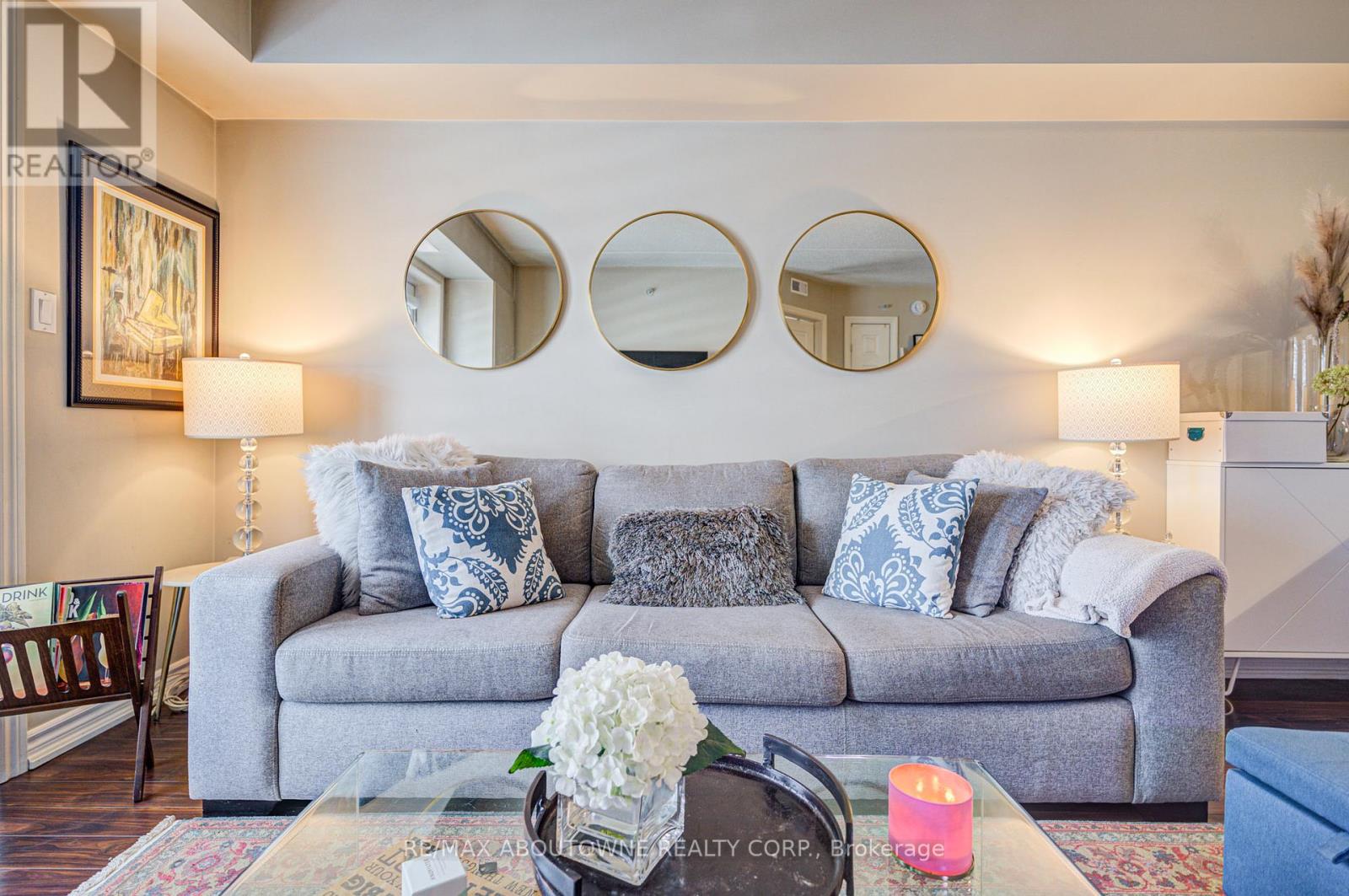 A grey couch with blue and white pillows sits in a living room.