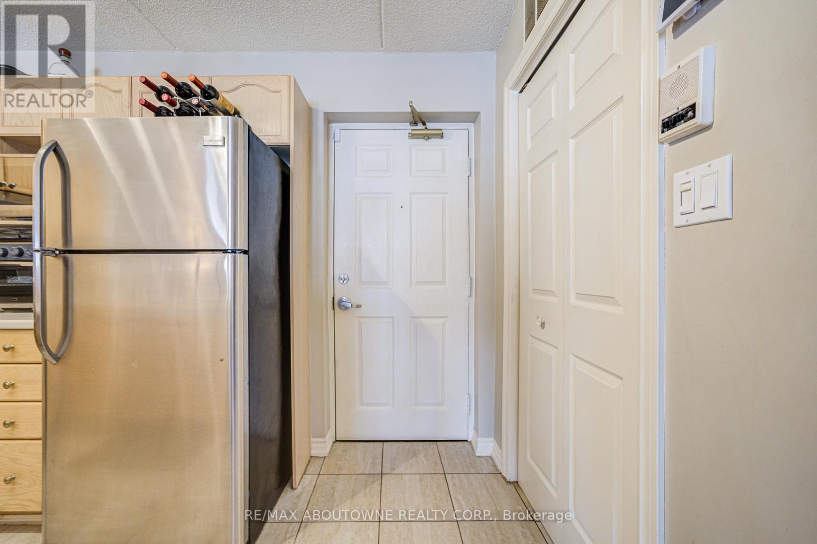 A kitchen with a stainless steel refrigerator and white door.