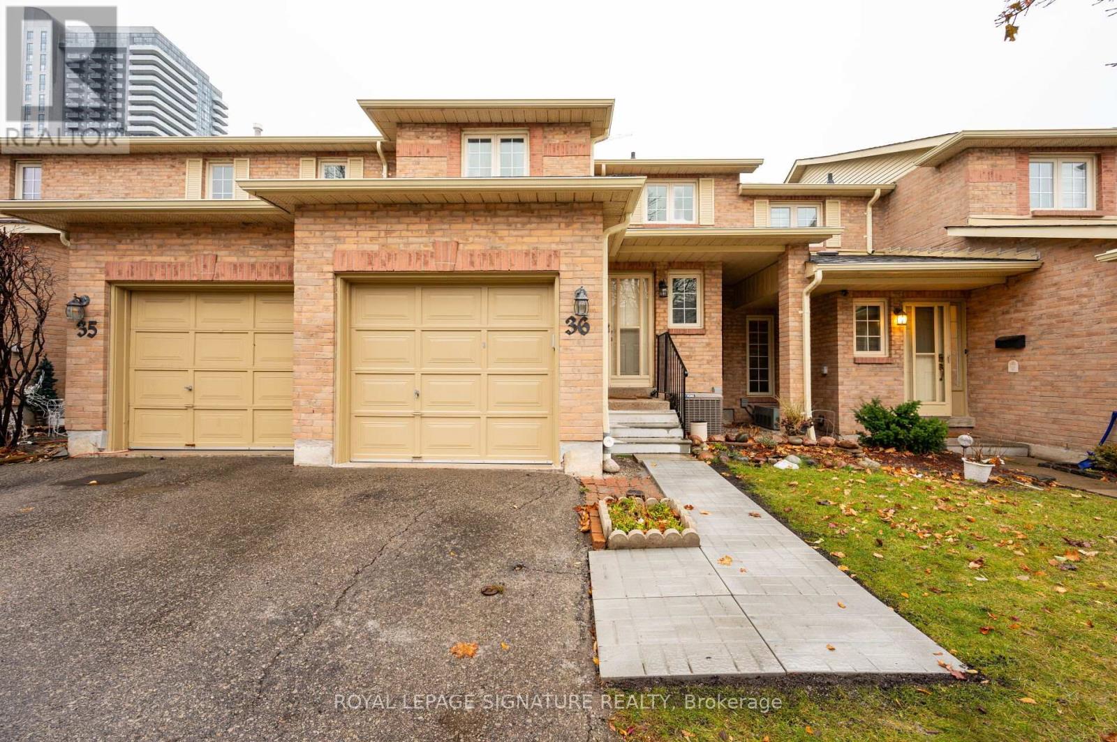 A house with a garage and a driveway in front of it.