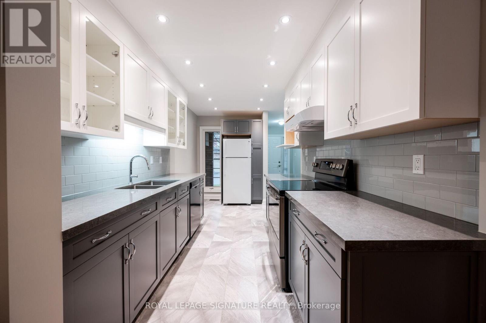 A modern kitchen with dark wood cabinets and a white refrigerator.