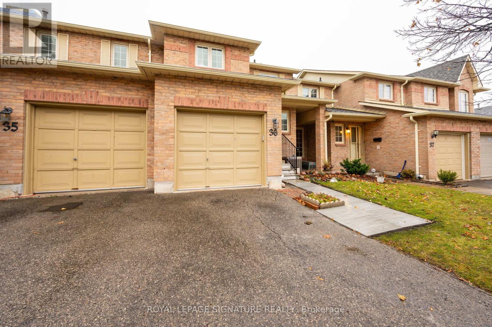 A large house with a driveway and two garages.