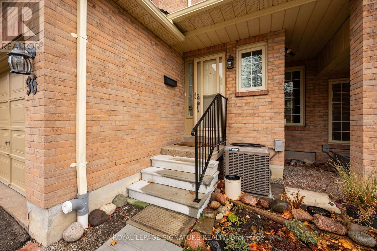 A brick house with a Royal LePage sign on the front.
