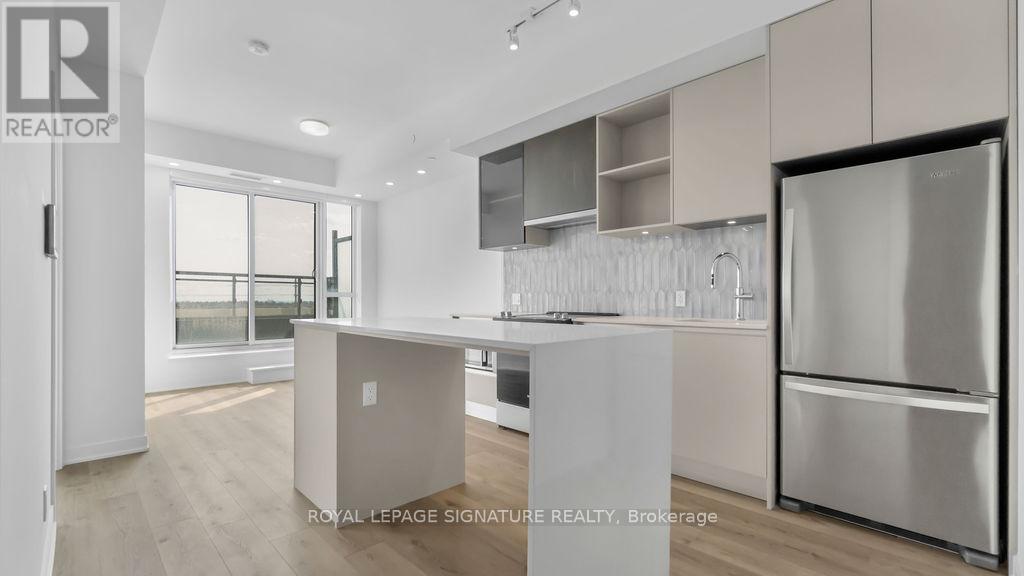 A modern kitchen with a refrigerator on the right side.