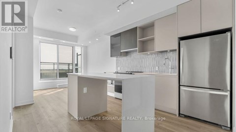 A modern kitchen with a refrigerator on the right side.