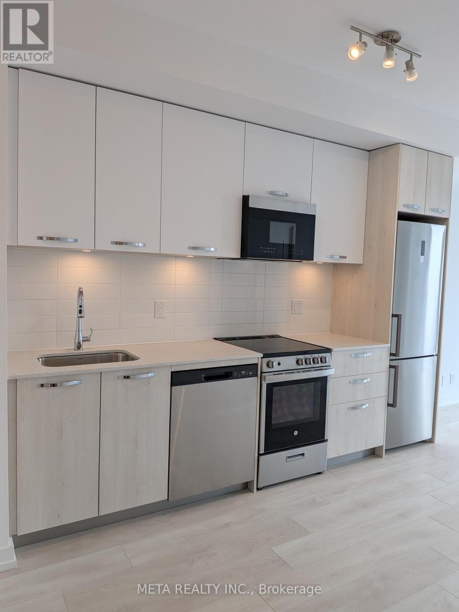 A modern kitchen with white cabinets and stainless steel appliances.