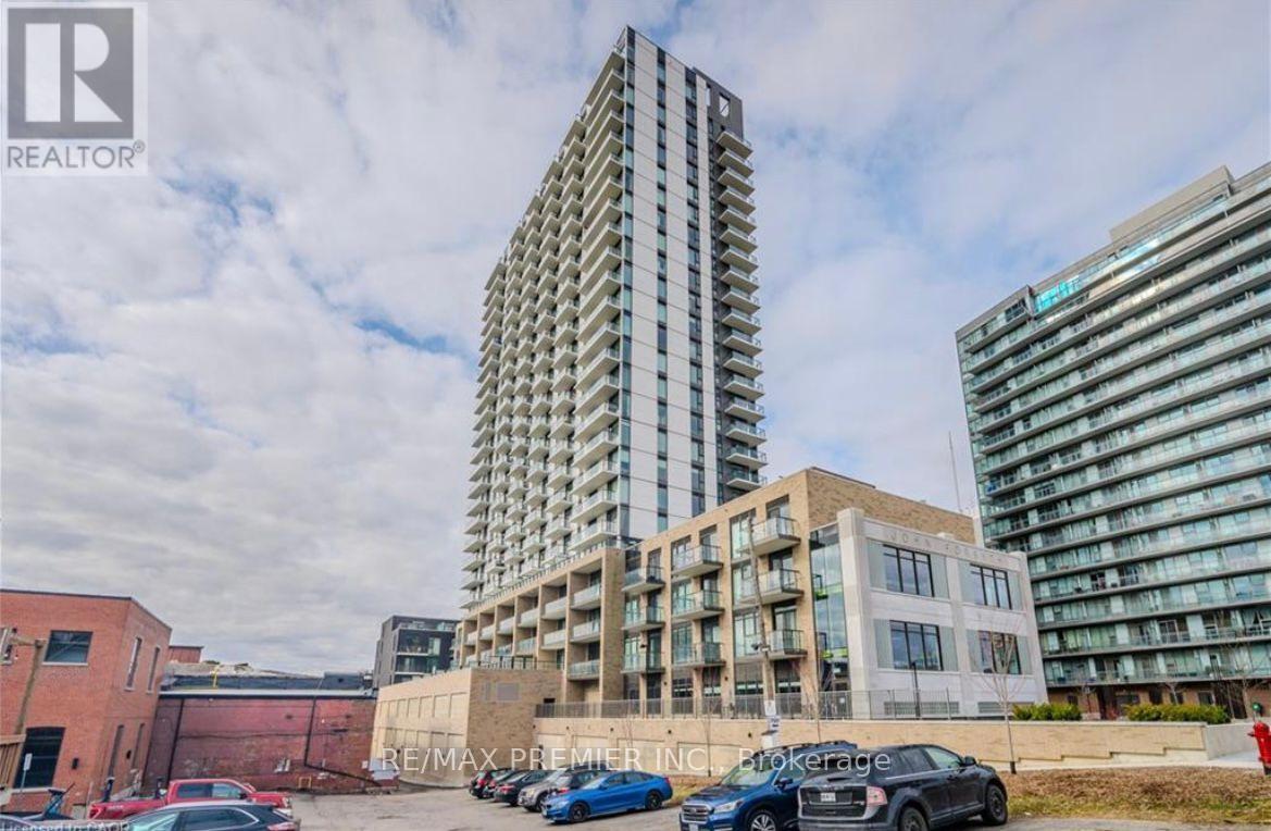 A tall building with a glass facade stands next to a shorter building with a brick facade.