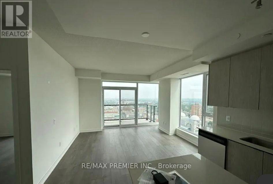 A spacious living room with a view of the cityscape.
