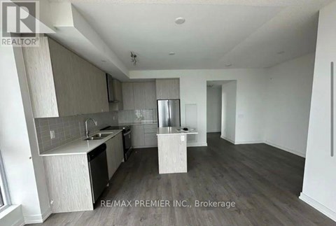 A kitchen with a sink and a refrigerator.