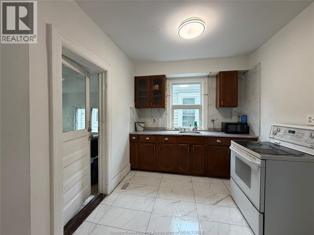 A kitchen with white appliances and brown cabinets.