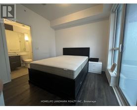 A bedroom with a large bed, a nightstand, and a small table.