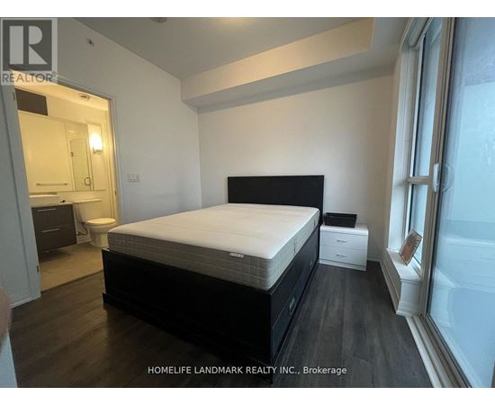A bedroom with a large bed, a nightstand, and a small table.