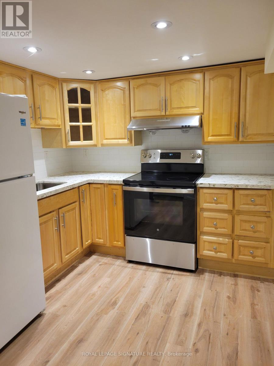 A kitchen with wooden cabinets and a white refrigerator.