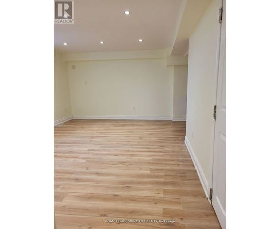 A room with wooden flooring and white walls.