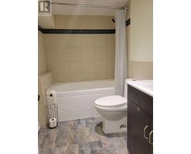 A white toilet sits next to a bathtub in a bathroom.